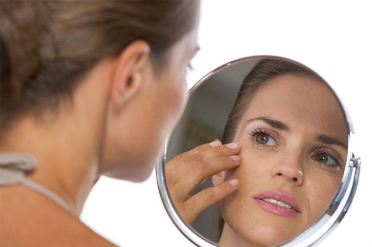 the girl looks in the mirror before skin rejuvenation